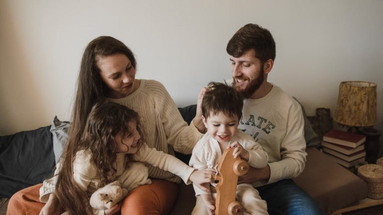 A joyful family of four sitting together on a sofa, enjoying their time with toys.
